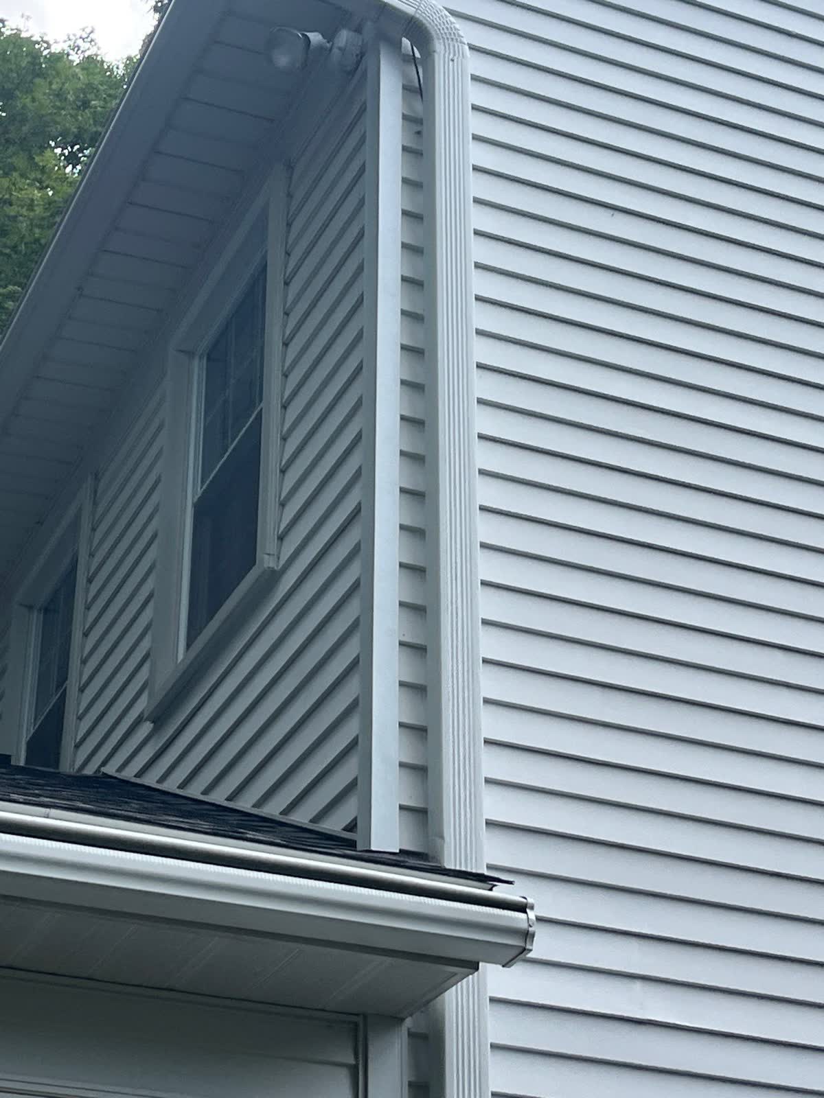 Close field view of an eave, gutter, vertical trim, and lap siding
