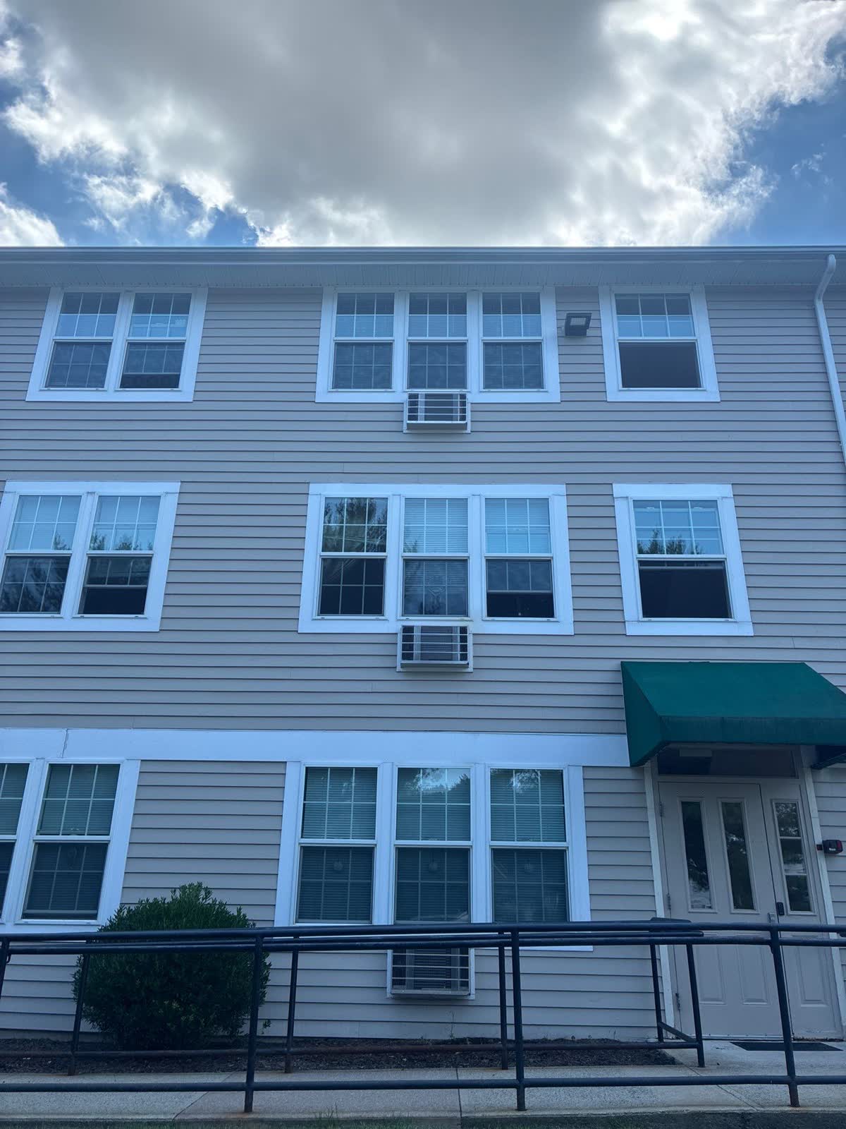 Full-height exterior facade with lap siding, windows, trim, and entry door
