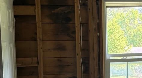 Interior wall opened for restoration beside two windows