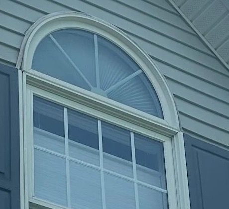 Finished arched window, siding, trim, and soffit detail